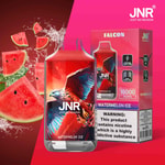 A JNR Falcon Watermelon Ice vape with a red and blue hawk design, surrounded by watermelon slices and water splashes, featuring 16,000 puffs and nicotine warning label.