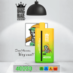 Bang Blaze Color vape device with green and yellow gradient, featuring a skeleton in a hoodie design, product branding, and icons indicating dual flavors, 4000 puffs, Type-C charging, and 40ml e-liquid capacity displayed under a lamp on a marble surface.