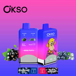 OKSO vape devices displaying blueberry ice and black currant double flavors, with images of black currant and blueberries, and a cartoon monkey wearing a hat on the packaging, set against a pink-purple gradient background.