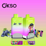 Two OKSO double flavor disposable vape devices with green and pink gradient design, featuring red energy ice and grape ice flavors, an illustrated monkey with a hat, and energy drink and grape images on a gradient background.