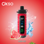 Dispositivo vape OKSO Shishai vermelho com display digital, cercado por respingos de água, cubos de gelo e fatias de melancia, com texto "LUSH ICE" na parte inferior.
