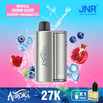 Um dispositivo vape prateado rotulado como 'Aurora' cercado por mirtilos, fatias de romã, cubos de gelo e respingos de água, contra um fundo gradiente colorido, com texto indicando o sabor 'Blueberry Pomegranate Ice'.
