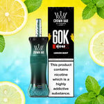 Crown Bar 60K EhoSex Lemon Mint vape med kricka svart böjd flaska bredvid en svart låda, omgiven av citronskivor och färsk mynta på en ljus gradient bakgrund.