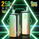 Dos dispositivos mod de vapeo verdes y negros con la etiqueta Quads 4in1, colocados en posición vertical sobre una superficie brillante iluminada con neón con un fondo futurista verde y amarillo.