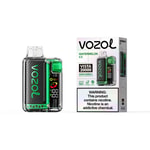 Vozoom Vista 20000 Vapor device with green and black carbon fiber design next to its white packaging labeled Vozol Watermelon Ice and a large nicotine warning label.