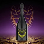 A tall dark champagne bottle with a black capsule and a yellow ornate label, set against a purple background with gold designs.