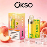 Dispositivo di vaporizzazione OKSO al gusto di ghiaccio alla pesca e scatola con motivo esagonale giallo-verde, pesche e cubetti di ghiaccio su sfondo rosa.
