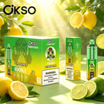 Bright lemons on a branch with green leaves and several green OKSO Tornado product boxes in a sunny outdoor setting.