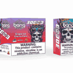 Emballage et dispositif de vape jetable pour Bang 30K PRO au goût Grape Ice Cherry Cola, avec un crâne coloré avec des flammes, la marque du produit et une étiquette d'avertissement de dépendance à la nicotine.