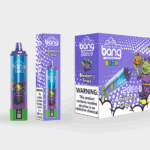 Un producto de vapeo desechable colorido y un empaque para "Bang Blaze" en sabor Blueberry Grape, que presenta una ilustración de un duende con temática de Halloween y una etiqueta de "2000 caladas", con una advertencia de nicotina.