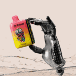 Robotyczna dłoń trzymająca kolorowe urządzenie do waporyzacji z napisem "GAZZBAR Strawberry Mango" z grafiką kapiącego potwora, rozpryskującego wodę.