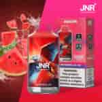 Un vaporizzatore JNR Falcon Watermelon Ice con un design di falco rosso e blu, circondato da fette di anguria e spruzzi d'acqua, con 16.000 boccate ed etichetta di avvertenza sulla nicotina.