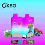 Two colorful OKSO vape devices featuring double flavors, mint and blue razz cherry cranberry, with illustrated fruit, mint leaves, and a cartoon character on the packaging, set against a blue-to-purple gradient background.