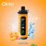 OKSO branded peach-flavored vape device with a digital display, surrounded by ice cubes, water splashes, and fresh peach fruit, labeled 'PEACH ICE' on an orange background.