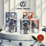 Three Crystal Twin 50K vape devices with futuristic astronaut-themed packaging displayed on a white platform, surrounded by blueberries and a halved grapefruit for flavor indication.