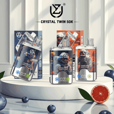 Drei Crystal Twin 50K-Vaporizer mit futuristischer Astronauten-Verpackung auf einer weißen Plattform, umgeben von Blaubeeren und einer halbierten Grapefruit zur Geschmacksanzeige.