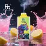 Dispositivo vape FUMOT Leopard 40K com design colorido de leopardo, emitindo vapor, colocado entre salpicos de bebidas rosa e rodelas de limão em uma superfície reflexiva.