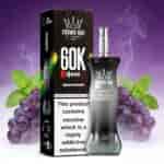 Una caja negra de Crown Bar con la etiqueta 60K E Hose X con sabor a uva y menta, que se muestra junto a un dispositivo de vapeo metálico, rodeada de uvas y hojas de menta sobre un fondo degradado de color púrpura.