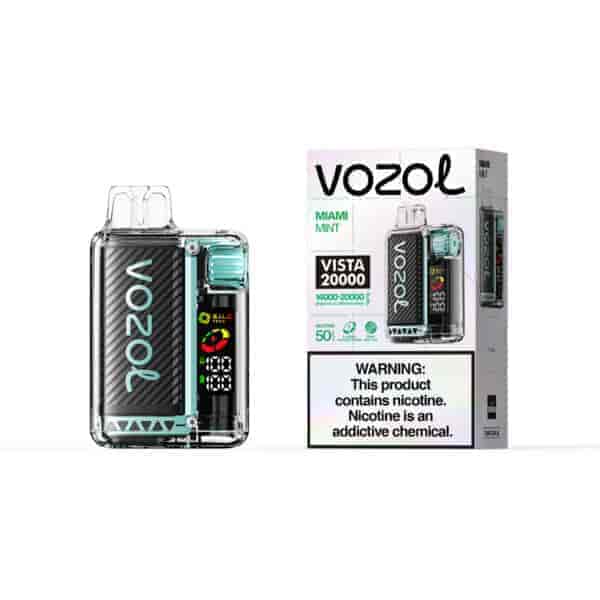 Appareil de vape Vozol Miami Mint Vista 20000 avec finition en fibre de carbone et accents turquoise à côté de son emballage en boîte blanche montrant les instructions et l'étiquette d'avertissement.