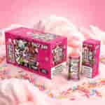 Emballage de bonbons roses colorés avec des graphismes de style graffiti, un fond de barbe à papa et des pépites; comprenant une boîte, une petite bouteille et un flacon.