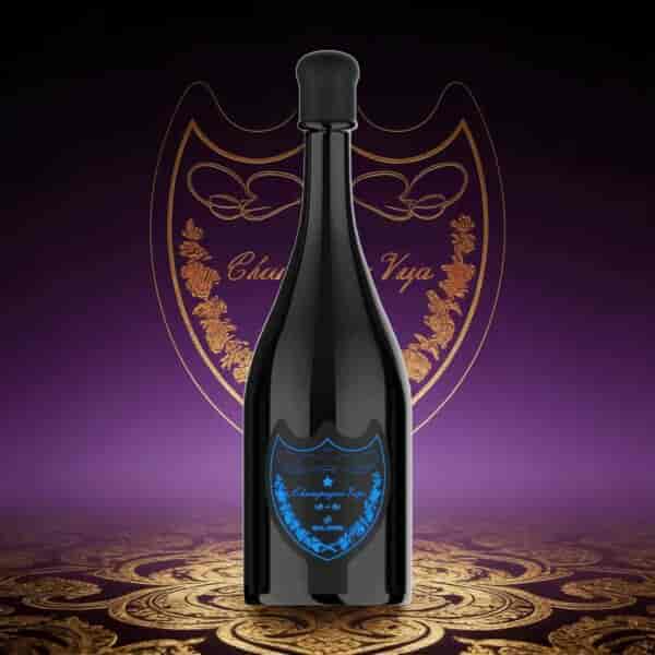 Une bouteille haute et sombre avec un bouchon noir arrondi, une étiquette ornée de bleu sur le devant, posée sur une surface décorative à motifs violet-or avec un emblème en forme de cœur en arrière-plan.