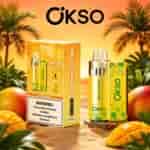 Mango-flavored Okso vaping device and packaging in a tropical desert setting with palm trees and sliced mangoes, yellow-green color scheme branding Mexico Mango.