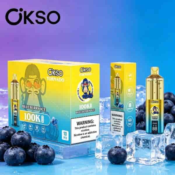 Scatole per vaping OKSO Tornado giallo brillante con sfondo sfumato blu e viola, mirtilli e cubetti di ghiaccio in primo piano.