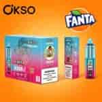 Esposizione di confezioni colorate per il marchio Okso Fanta, con diversi prodotti in scatola su sfondo arancione brillante e etichette di avvertenza.