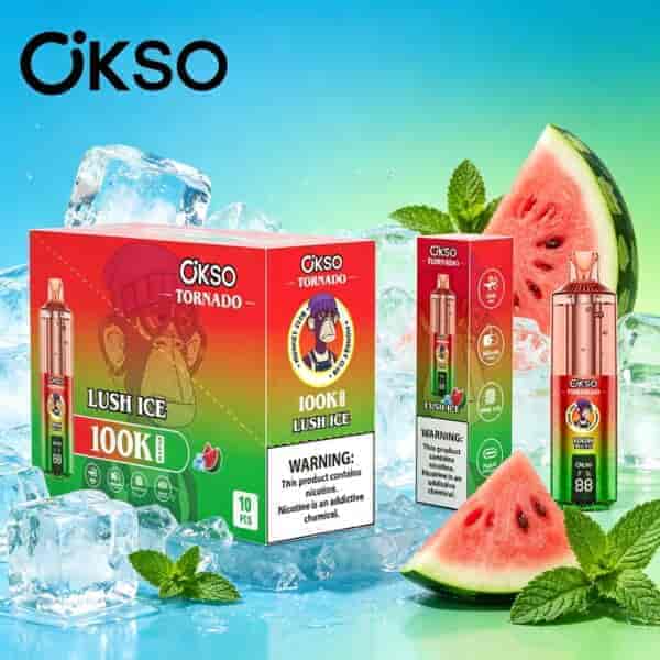 Scatole di prodotti Ökso Tornado rosso brillante con foglie di menta, fette di anguria e cubetti di ghiaccio su uno sfondo sfumato blu-verde.
