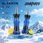 Two vaping devices with a blue and black design labeled "AL SAHIM" and "ATVS," set against a snowy backdrop with lemon and lime halves nearby